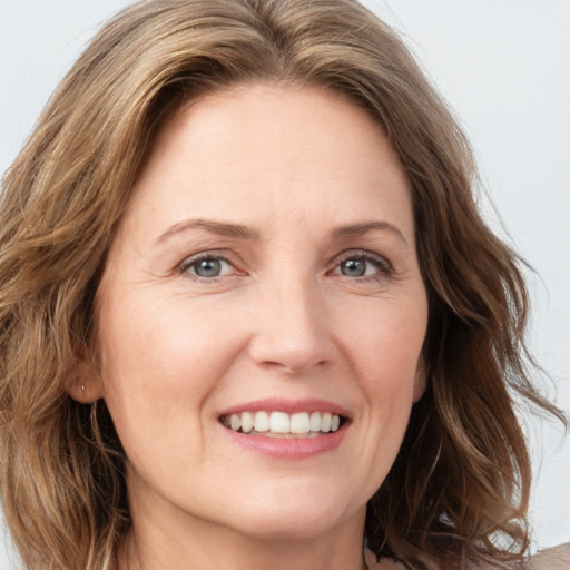 Joyful white adult female with medium  brown hair and green eyes