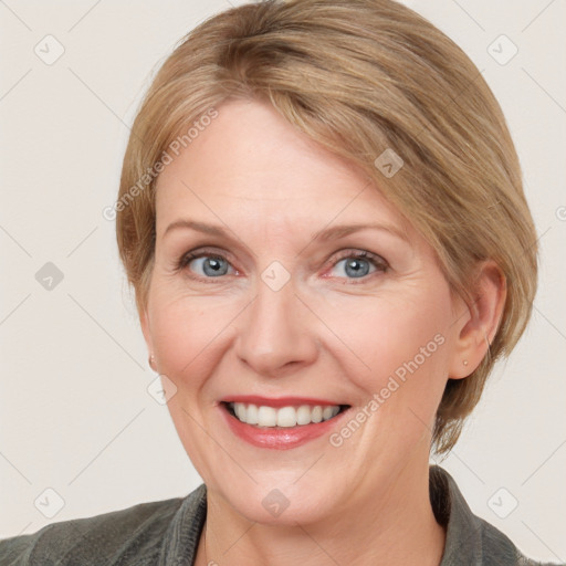 Joyful white adult female with medium  brown hair and blue eyes