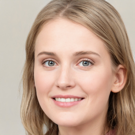 Joyful white young-adult female with long  brown hair and blue eyes