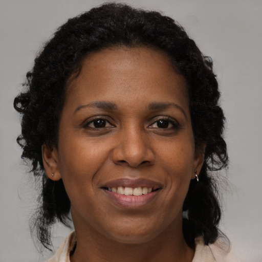 Joyful black adult female with medium  brown hair and brown eyes