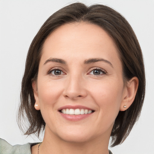 Joyful white young-adult female with medium  brown hair and grey eyes