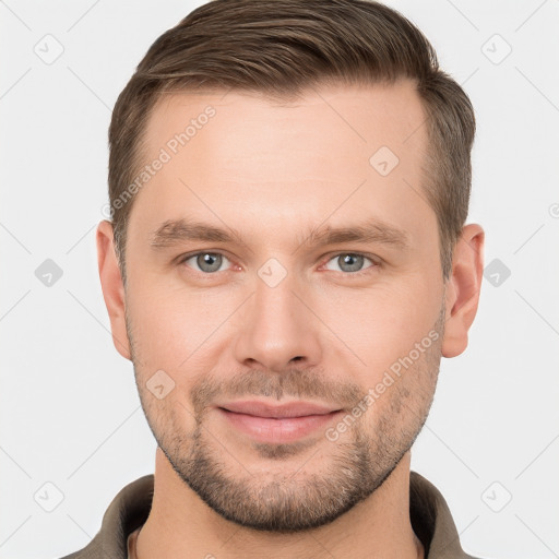 Joyful white young-adult male with short  brown hair and grey eyes