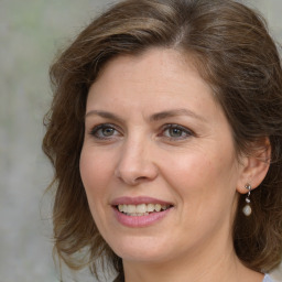 Joyful white adult female with medium  brown hair and brown eyes