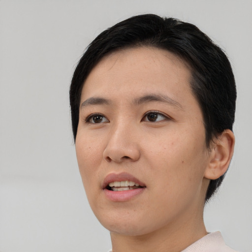 Joyful asian young-adult female with short  black hair and brown eyes