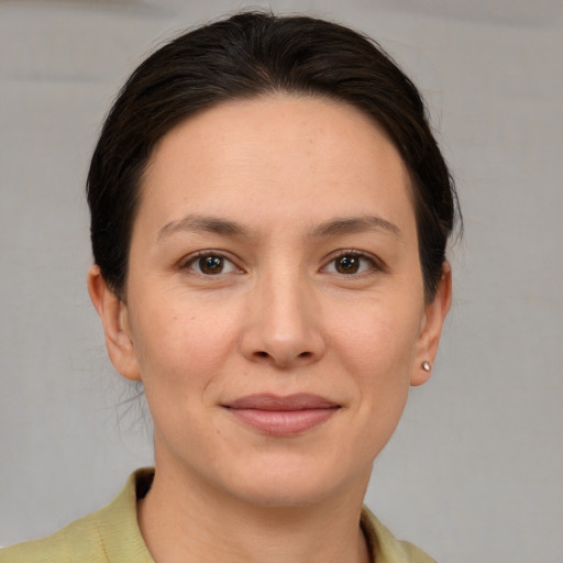 Joyful white young-adult female with short  brown hair and grey eyes