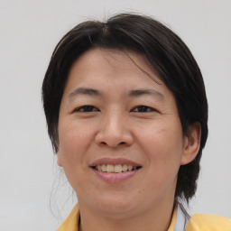 Joyful asian adult female with medium  brown hair and brown eyes