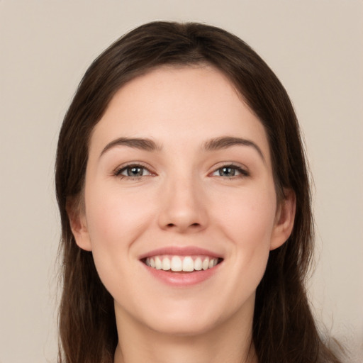 Joyful white young-adult female with long  brown hair and brown eyes