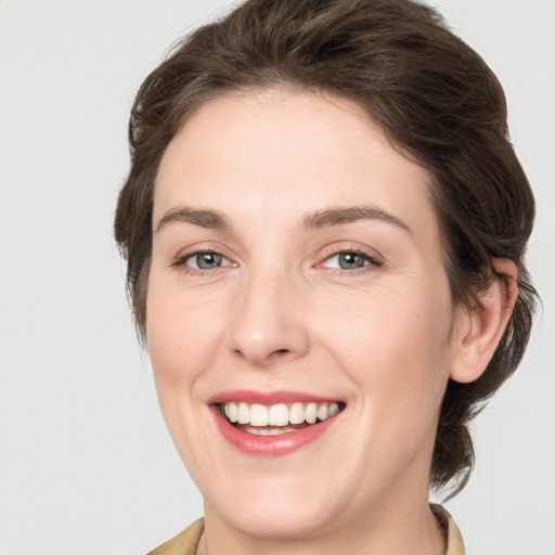 Joyful white young-adult female with medium  brown hair and grey eyes