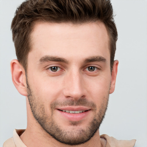 Joyful white young-adult male with short  brown hair and grey eyes