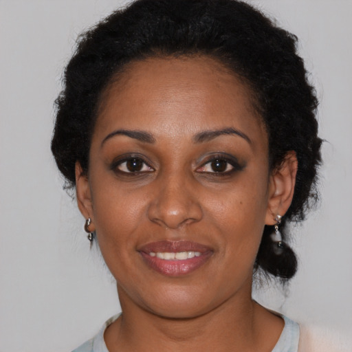 Joyful black young-adult female with medium  brown hair and brown eyes
