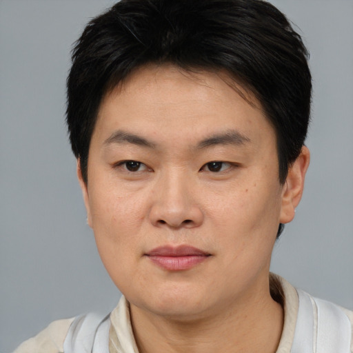 Joyful asian young-adult male with short  brown hair and brown eyes