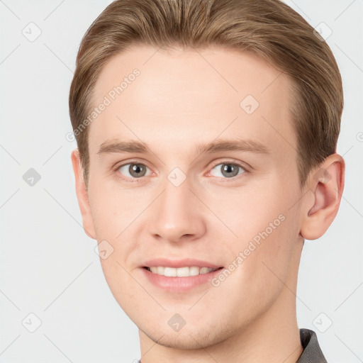 Joyful white young-adult male with short  brown hair and grey eyes