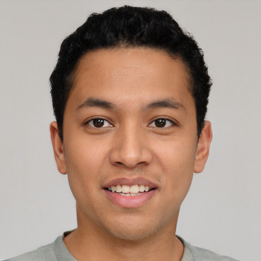 Joyful latino young-adult male with short  black hair and brown eyes