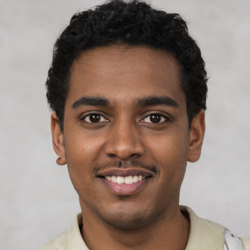 Joyful black young-adult male with short  black hair and brown eyes