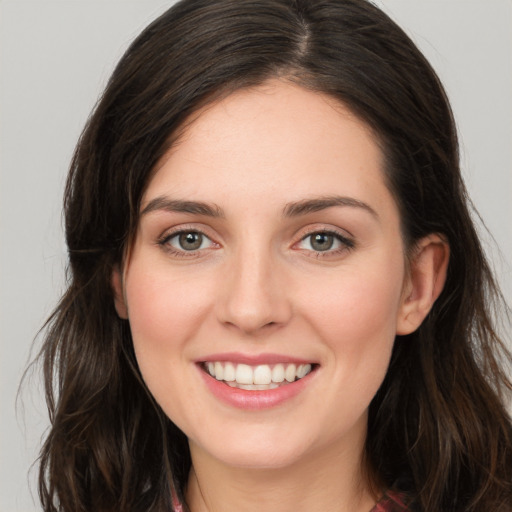 Joyful white young-adult female with long  brown hair and green eyes