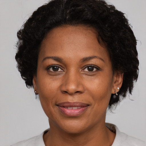 Joyful black adult female with short  brown hair and brown eyes