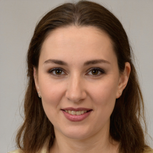 Joyful white young-adult female with long  brown hair and brown eyes