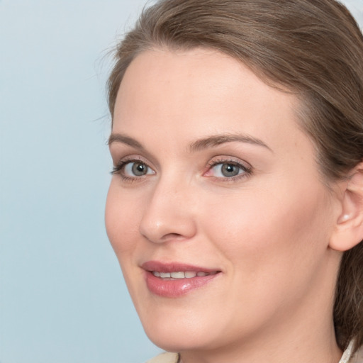 Joyful white young-adult female with medium  brown hair and blue eyes