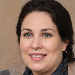 Joyful white adult female with medium  brown hair and brown eyes