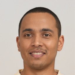 Joyful latino young-adult male with short  black hair and brown eyes