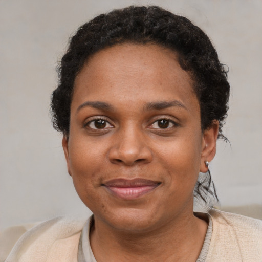 Joyful black young-adult female with short  brown hair and brown eyes