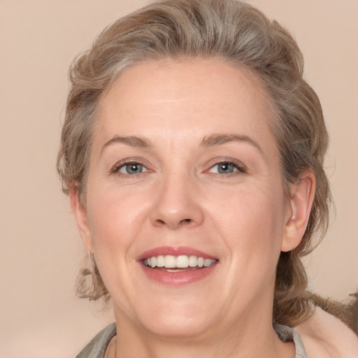 Joyful white adult female with medium  brown hair and grey eyes