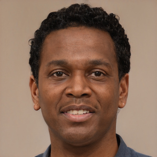 Joyful black young-adult male with short  brown hair and brown eyes
