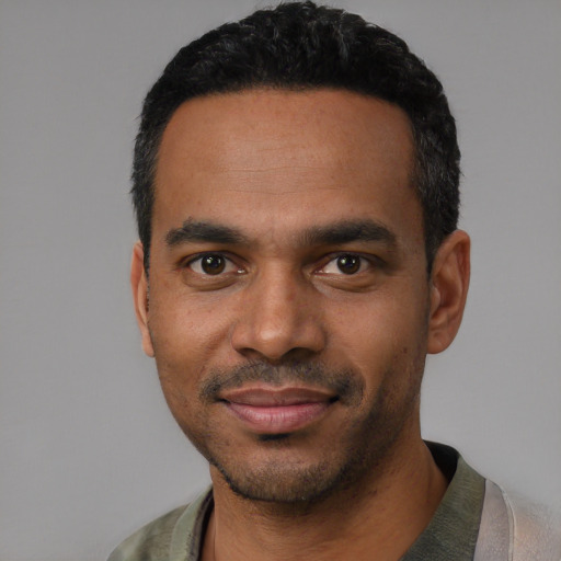 Joyful black young-adult male with short  black hair and brown eyes