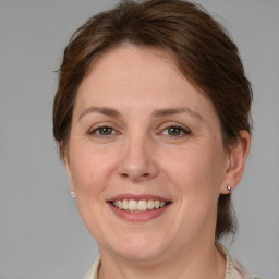 Joyful white adult female with medium  brown hair and grey eyes