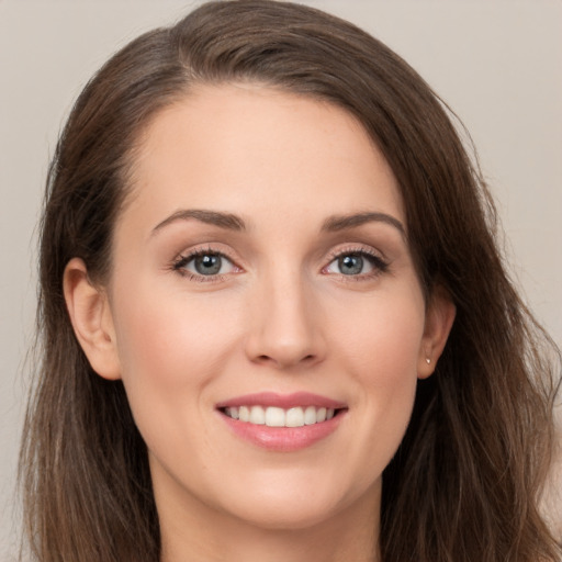 Joyful white young-adult female with long  brown hair and grey eyes