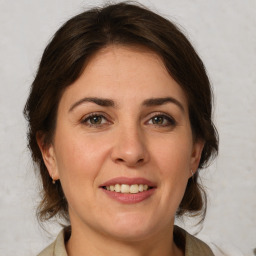 Joyful white young-adult female with medium  brown hair and green eyes