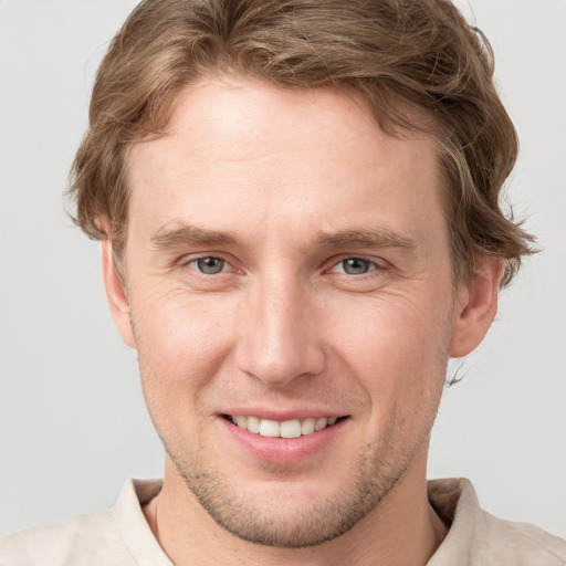 Joyful white young-adult male with short  brown hair and grey eyes