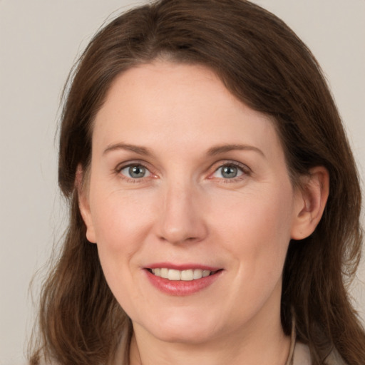 Joyful white young-adult female with medium  brown hair and grey eyes