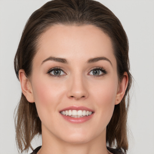 Joyful white young-adult female with medium  brown hair and grey eyes