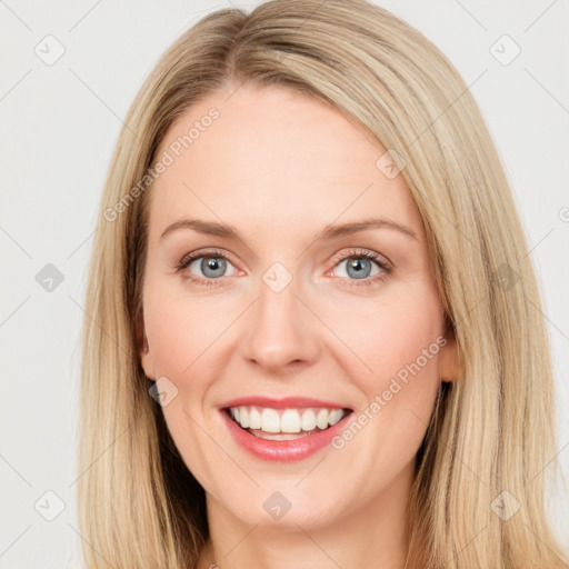 Joyful white young-adult female with long  brown hair and blue eyes