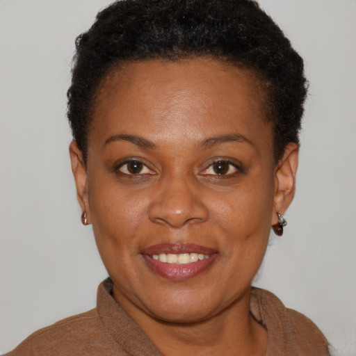 Joyful black young-adult female with short  brown hair and brown eyes
