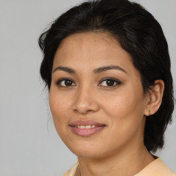 Joyful latino young-adult female with medium  brown hair and brown eyes