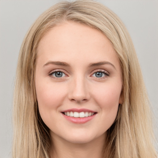 Joyful white young-adult female with long  brown hair and blue eyes