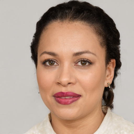 Joyful latino adult female with medium  brown hair and brown eyes
