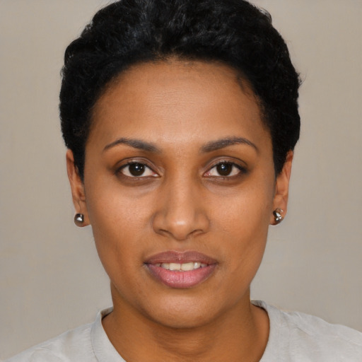 Joyful black young-adult female with short  black hair and brown eyes