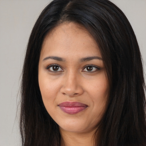 Joyful latino young-adult female with long  brown hair and brown eyes