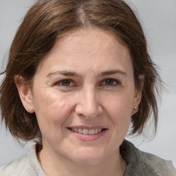 Joyful white adult female with medium  brown hair and grey eyes