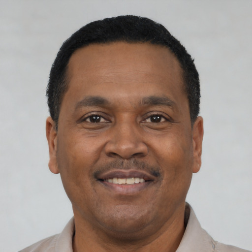 Joyful black adult male with short  black hair and brown eyes