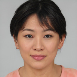 Joyful asian young-adult female with medium  brown hair and brown eyes