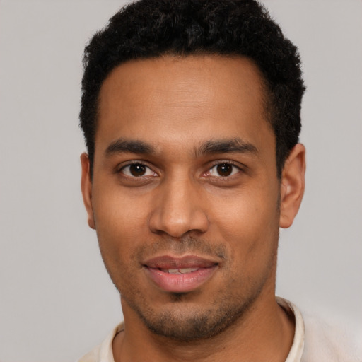 Joyful black young-adult male with short  black hair and brown eyes