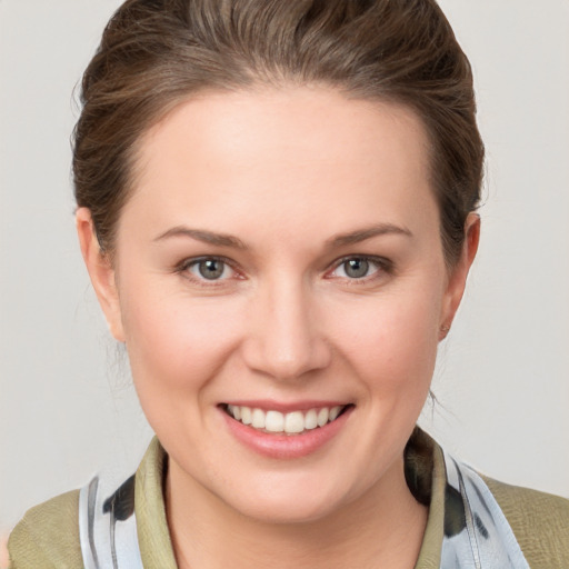 Joyful white young-adult female with medium  brown hair and grey eyes