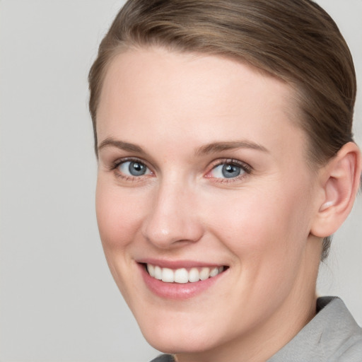 Joyful white young-adult female with short  brown hair and blue eyes