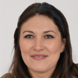 Joyful white adult female with long  brown hair and brown eyes