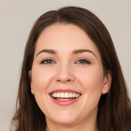 Joyful white young-adult female with long  brown hair and brown eyes