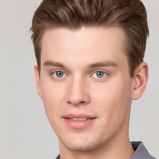 Joyful white young-adult male with short  brown hair and grey eyes